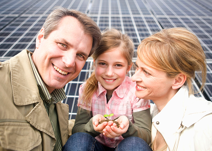 happy family in front of solar panels